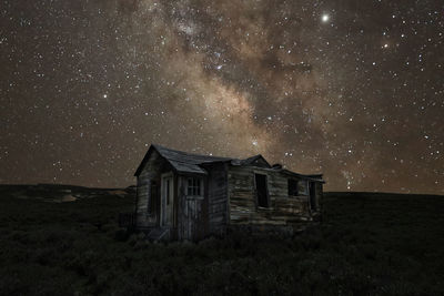 House on field against sky at night