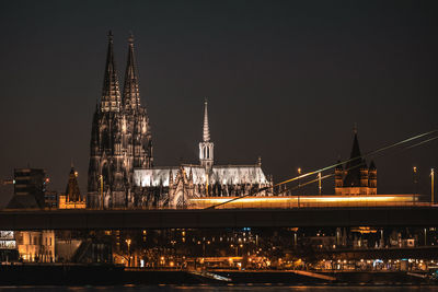 View of illuminated bridge and buildings at night