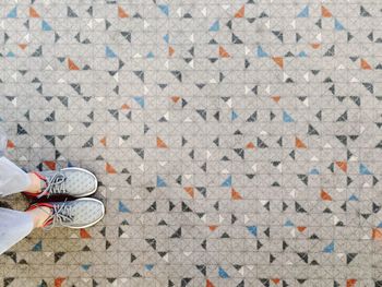 Low section of woman standing on footpath