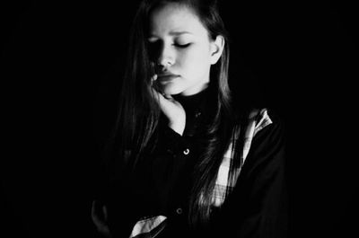 Young woman looking up over black background