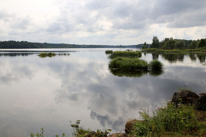 SCENIC VIEW OF CALM LAKE AGAINST CLOUDY SKY