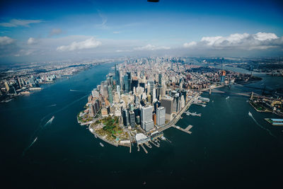 High angle view of sea and city buildings against sky