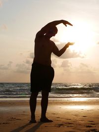 Full length of silhouette person standing on beach during sunset