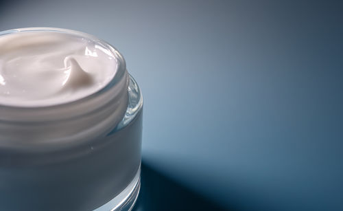 Close-up of drinking glass against blue background