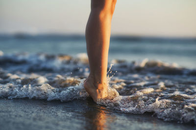 Low section of woman standing on beach