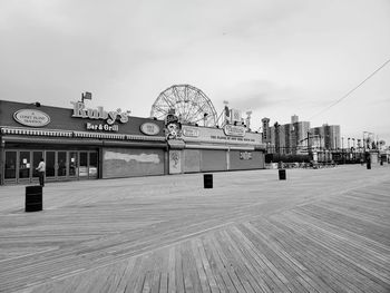 View of ferris wheel in city against sky