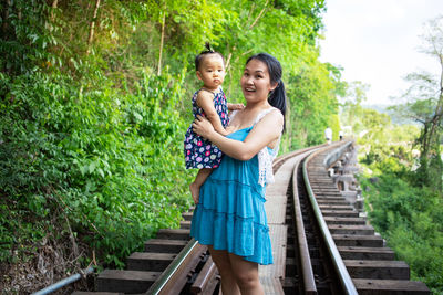 Happy friends standing on railroad track