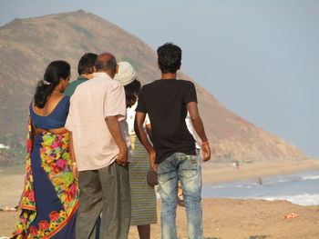 Rear view of people standing on mountain road