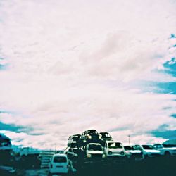 Cars on road against cloudy sky