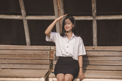 Portrait of young woman sitting on bench