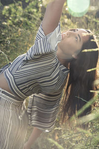 Pretty latina woman in sunshine and flower fields