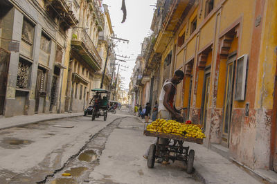 People on road amidst buildings in city