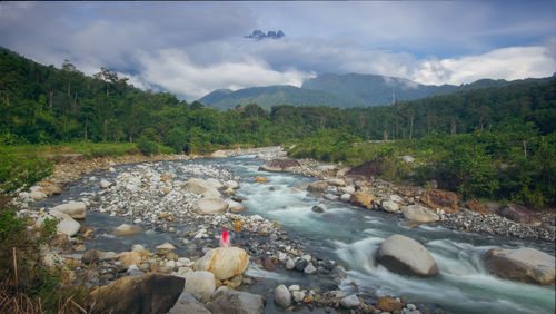 Scenic view of river amidst mountains against sky