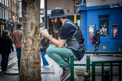 Man holding statue on street in city