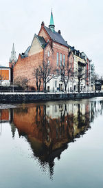 Reflection of building in lake against sky