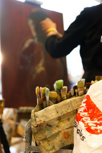 Midsection of person painting canvas 