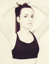 Portrait of young woman standing against white background