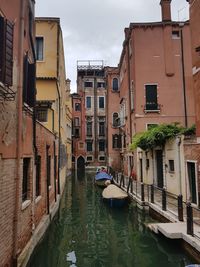 Venice canal amidst buildings in city against sky