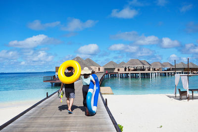 Man with umbrella on sea against sky