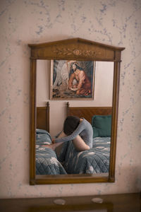 Reflection of young woman wearing bodysuit on mirror at home