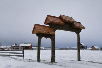 Gazebo on beach against sky during winter