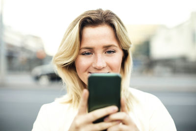 Young woman using mobile phone in city