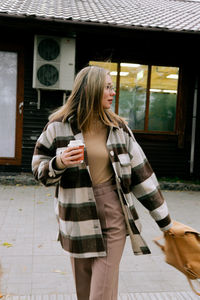 Full length of woman standing on footpath