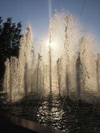 Water splashing in fountain against sky