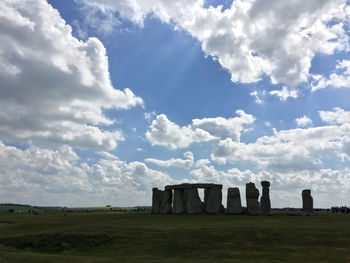 Built structure on field against cloudy sky