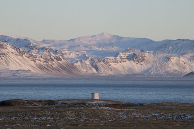 Scenic view of sea and mountains against clear sky