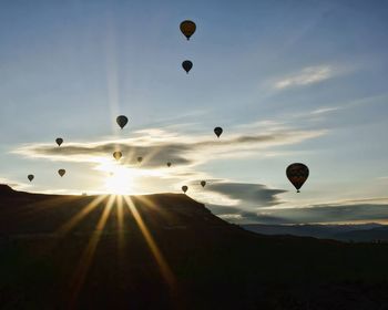 Silhouettes of hot air balloons at sunny day