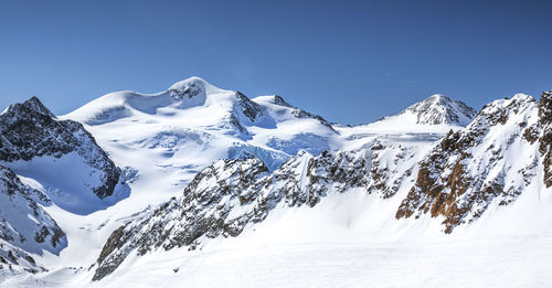 Scenic view of snowcapped mountains against clear blue sky