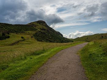 Road leading towards mountains against sky