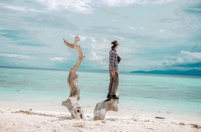 Full length of man standing on beach against sky