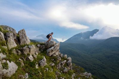 Man standing on rocks against mountains