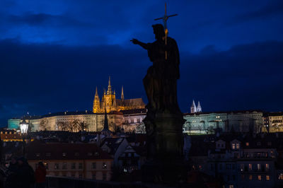 Statue in city at night