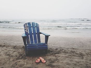 Empty chair on shore at beach