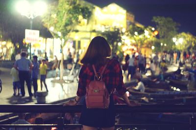 Rear view of women in illuminated city at night