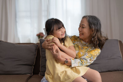 Smiling grandmother playing with granddaughter