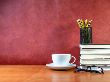 Coffee cup on table against wall
