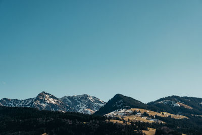 Scenic view of snowcapped mountains against clear blue sky