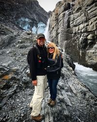 Portrait of couple standing against waterfall