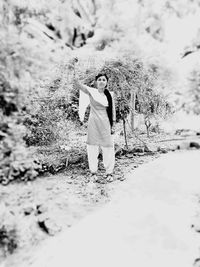 Portrait of person standing by tree on field