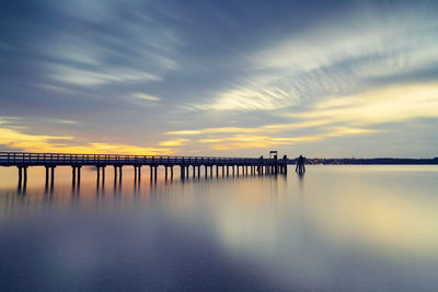 Bridge over river against sky during sunset