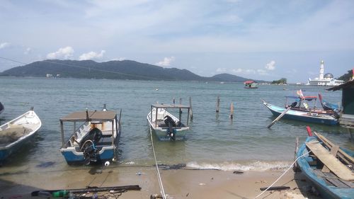 Boats moored on sea against sky