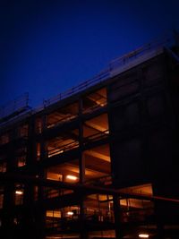 Low angle view of illuminated building against sky at dusk