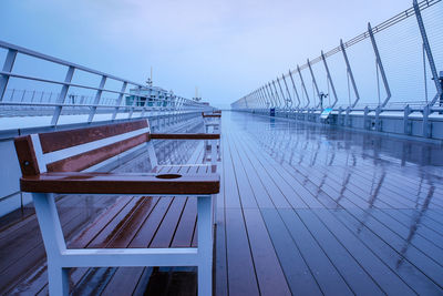 Empty bridge over sea against sky