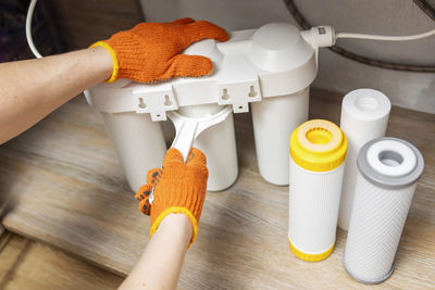 Cropped image of woman holding equipment on table