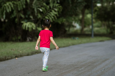 Rear view of girl standing on footpath