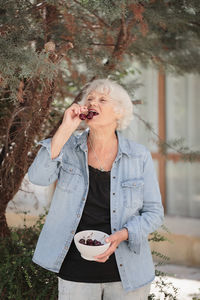 Elderly woman holding a bowl of ripe cherries